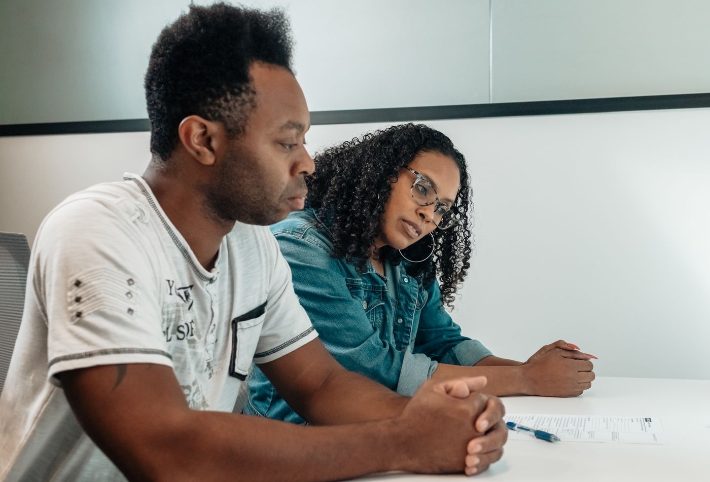 Stock photo of a couple reviewing a printed document together at a table