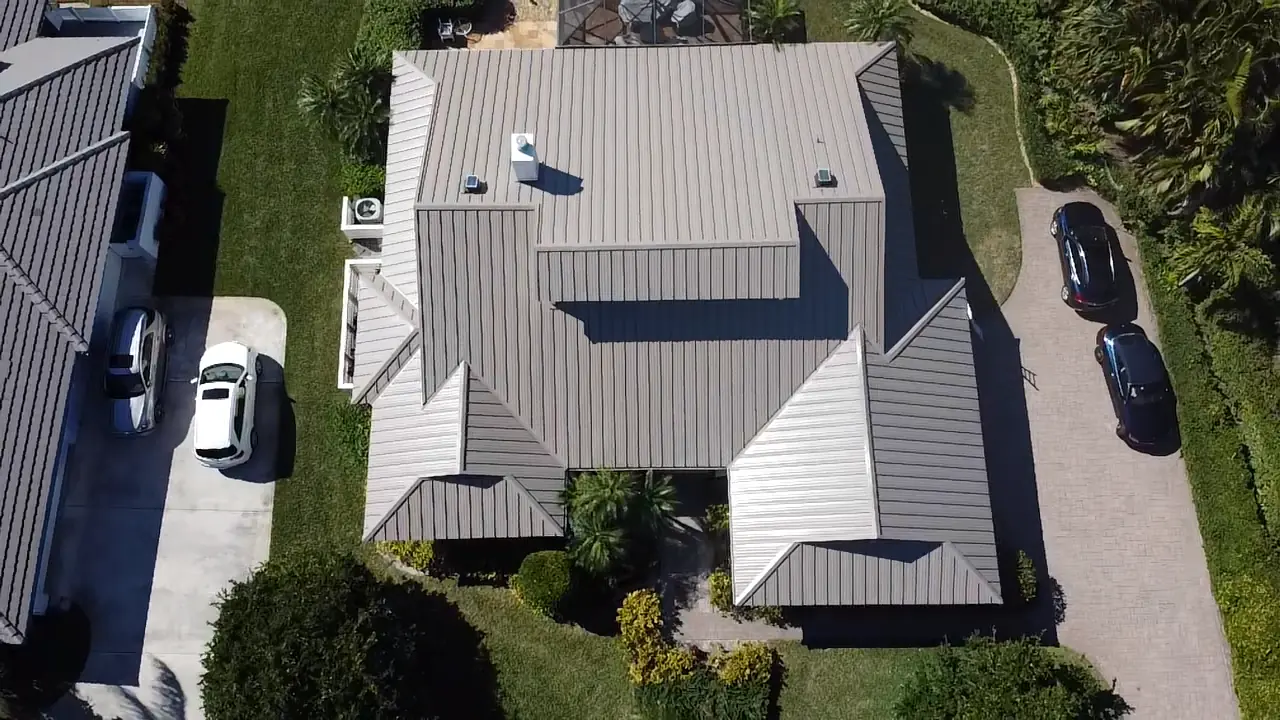 Top-down aerial view of a gray standing-seam metal roof with multiple roof sections.