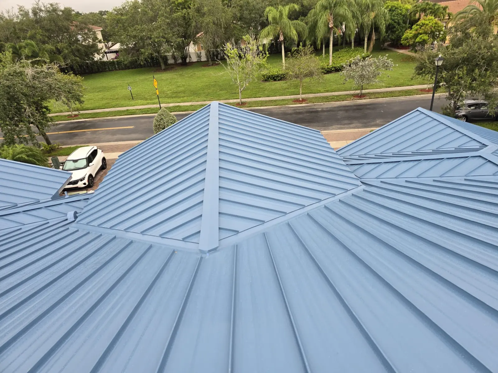 Completed 24-gauge Regal Blue standing-seam roof across adjoining roof sections in Miramar, Florida.
