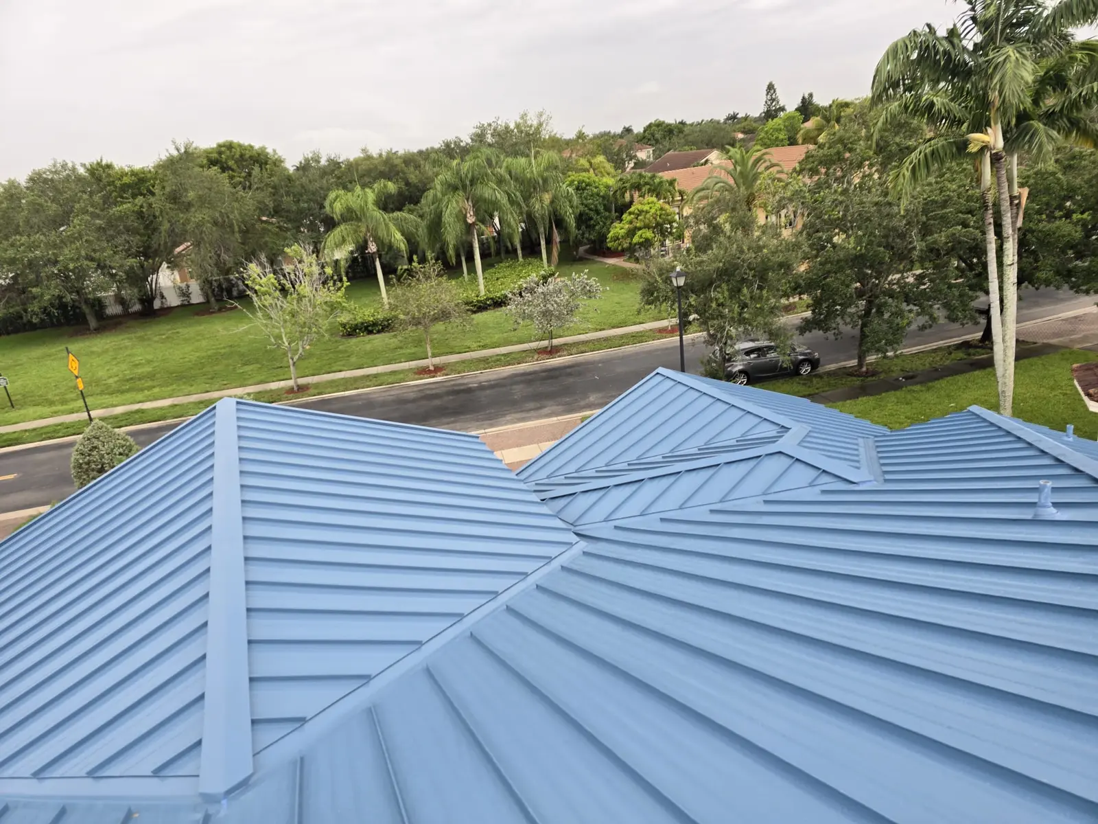 Completed 1.5-inch mechanically seamed Regal Blue roof with finished hips and valleys in Miramar.