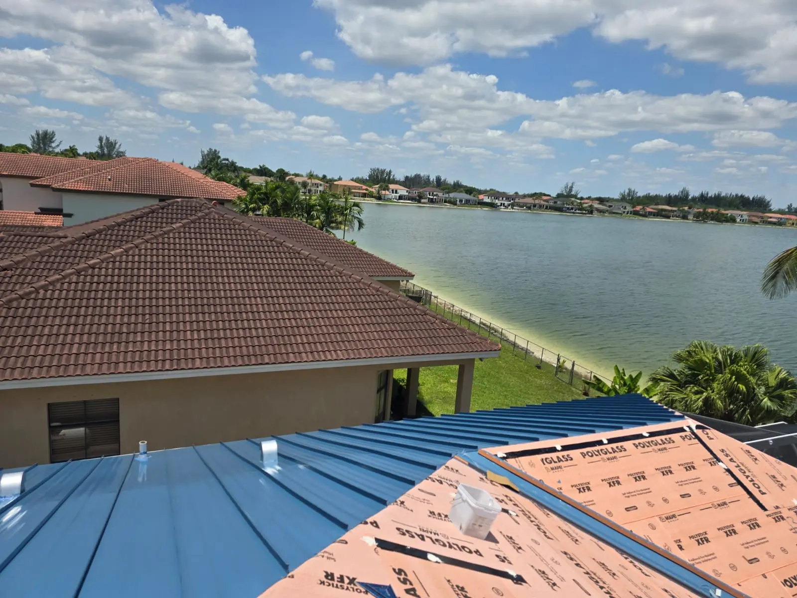 Regal Blue panels and Polystick XFR underlayment during a Miramar standing-seam roof installation.