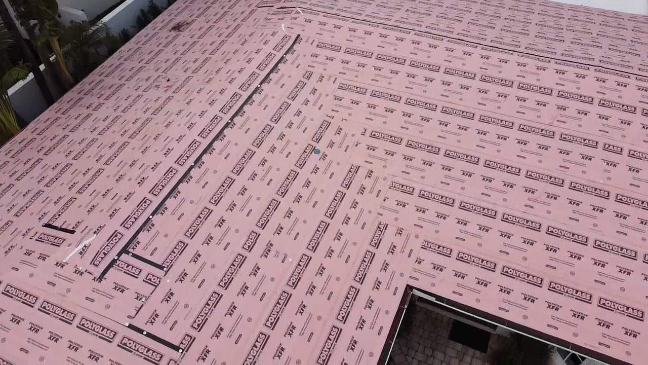 Close aerial view of Polystick XFR courses, laps and roof penetrations during a metal roof dry-in.
