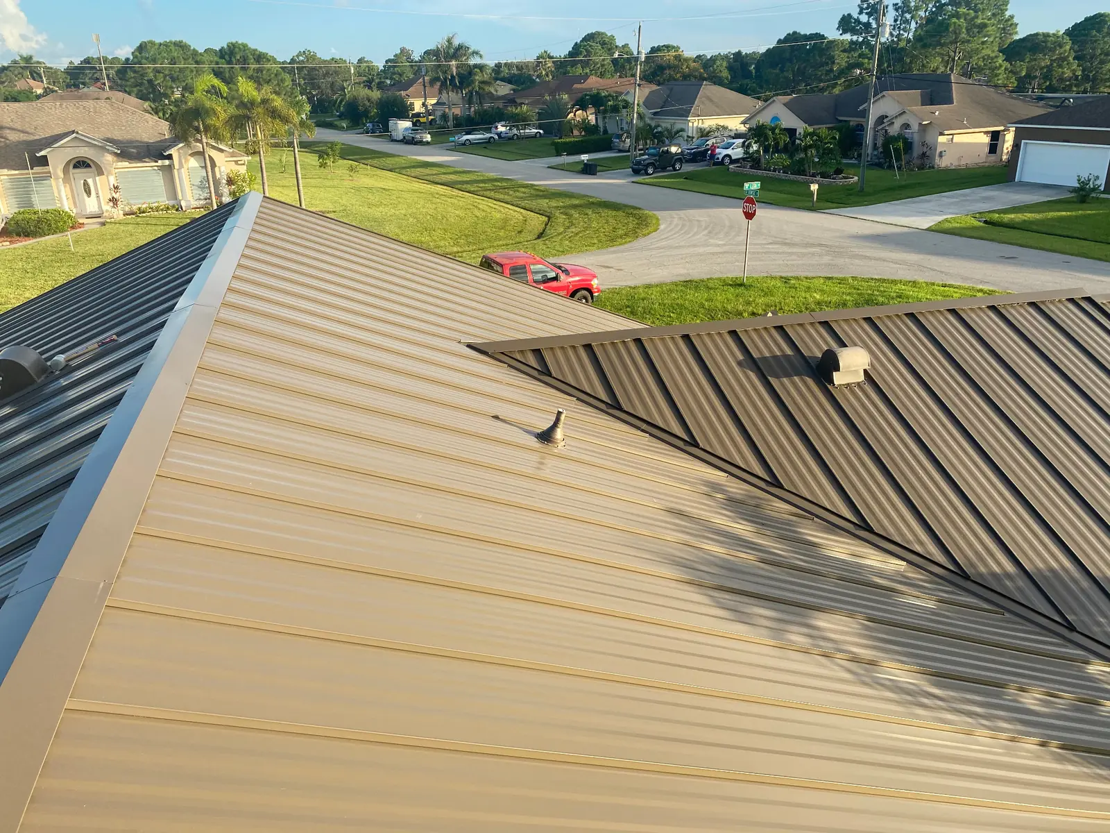Close view of bronze and dark-brown standing-seam metal roof panels on a residential roof