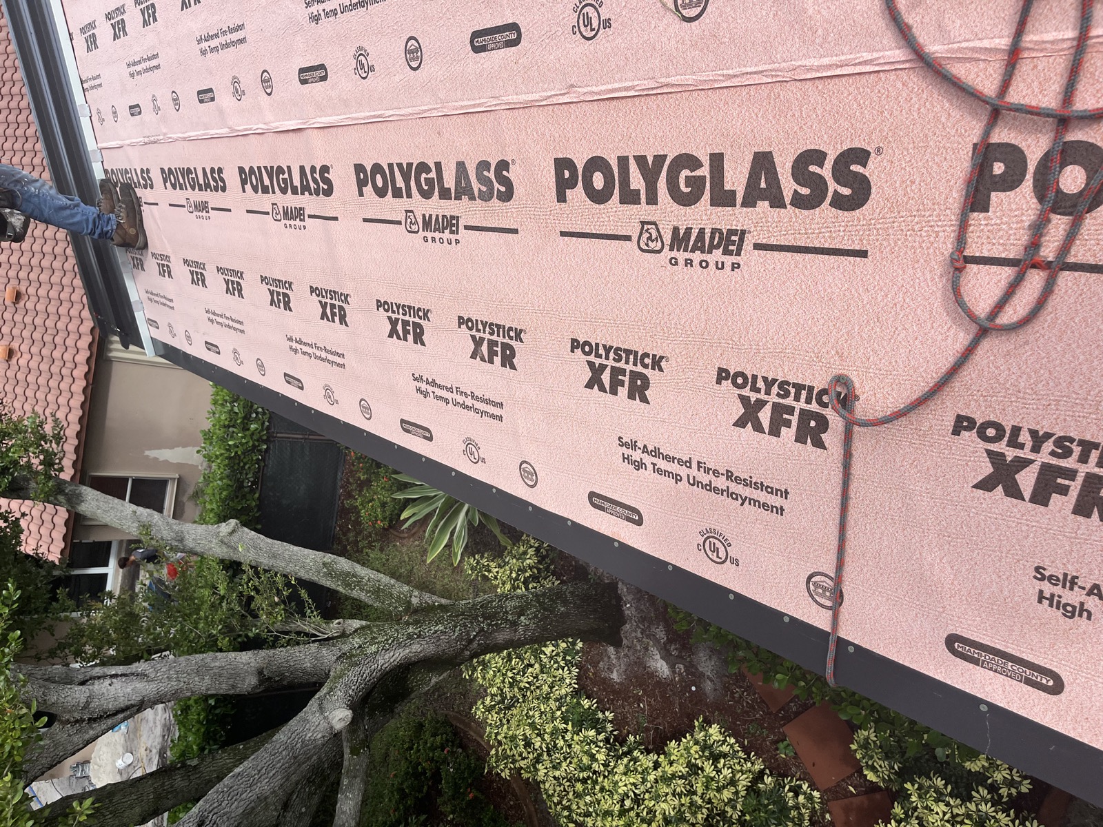Polystick XFR underlayment visible on the Coconut Creek roof during metal panel installation