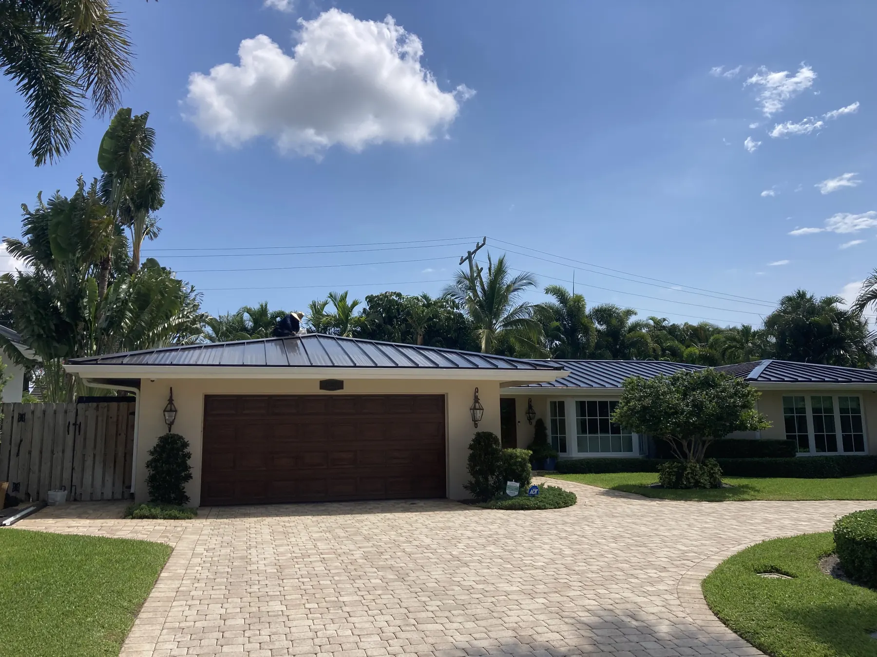 Street view of a completed dark gray standing-seam metal roof on a single-story home.