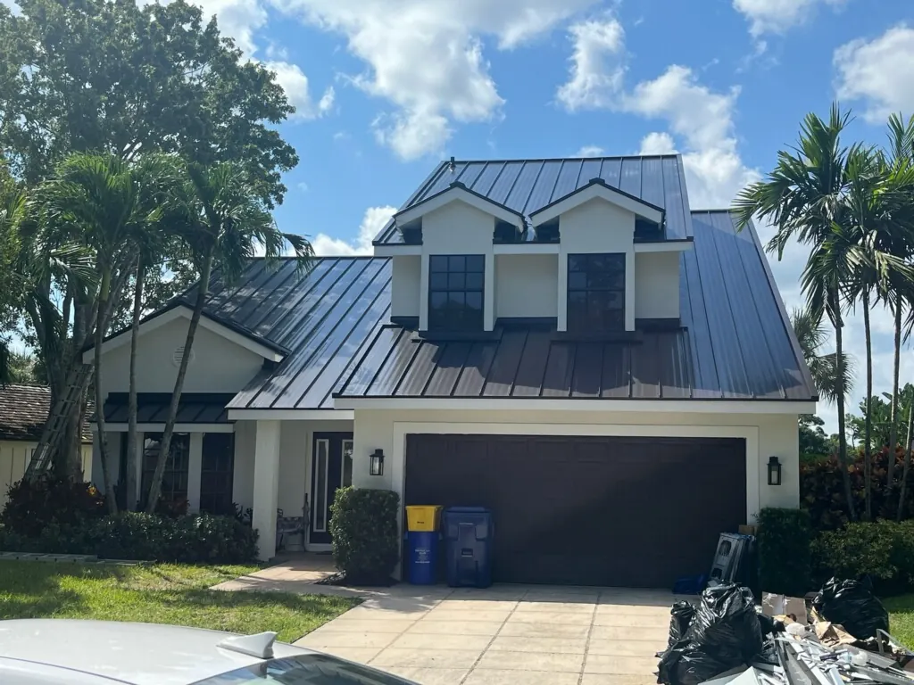 Two-story Florida home with a completed dark gray standing-seam metal roof.