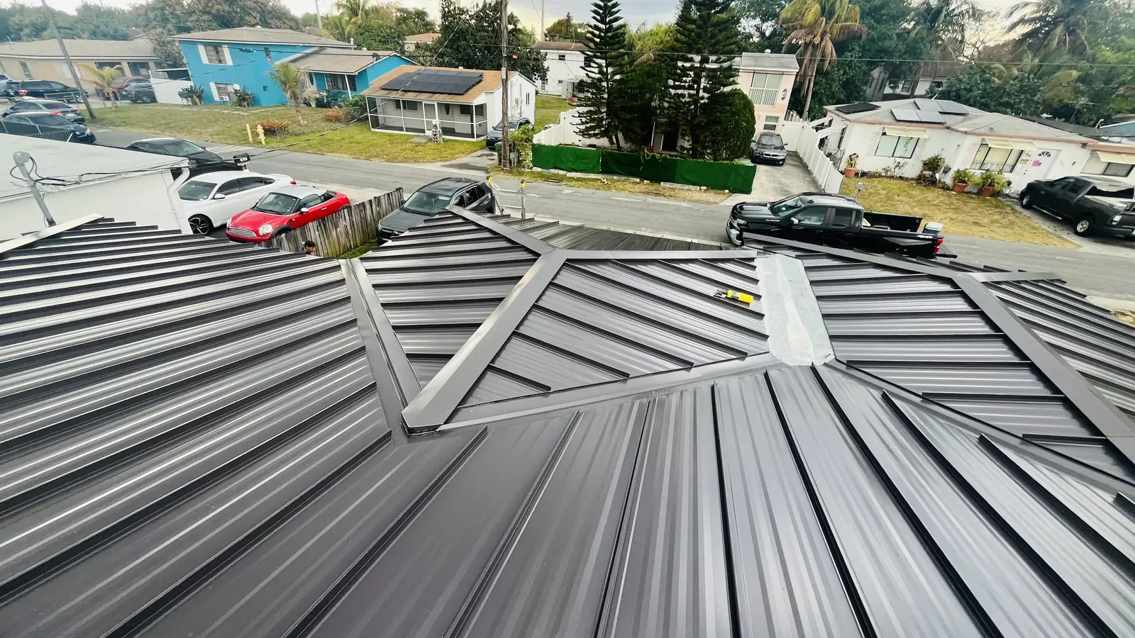 Elevated view across a completed dark standing-seam metal roof in Boca Raton, Florida.