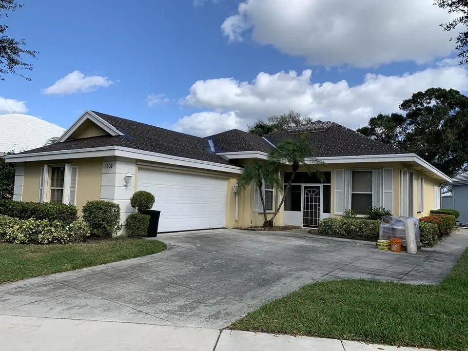 Street view of a single-story home with a dark concrete tile roof.