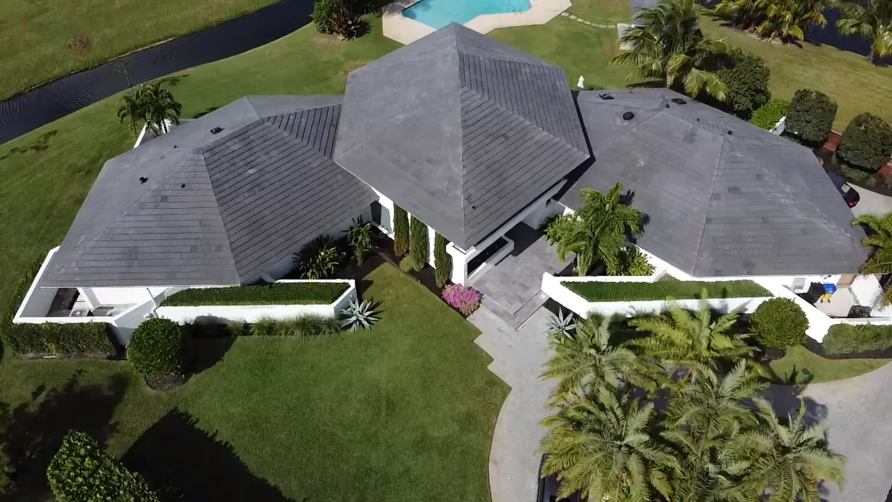 Aerial view of a completed gray tile roof on a single-story pool home.