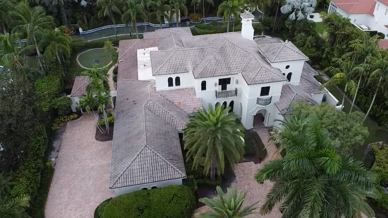 Aerial view of a large home with a completed light-colored tile roof.