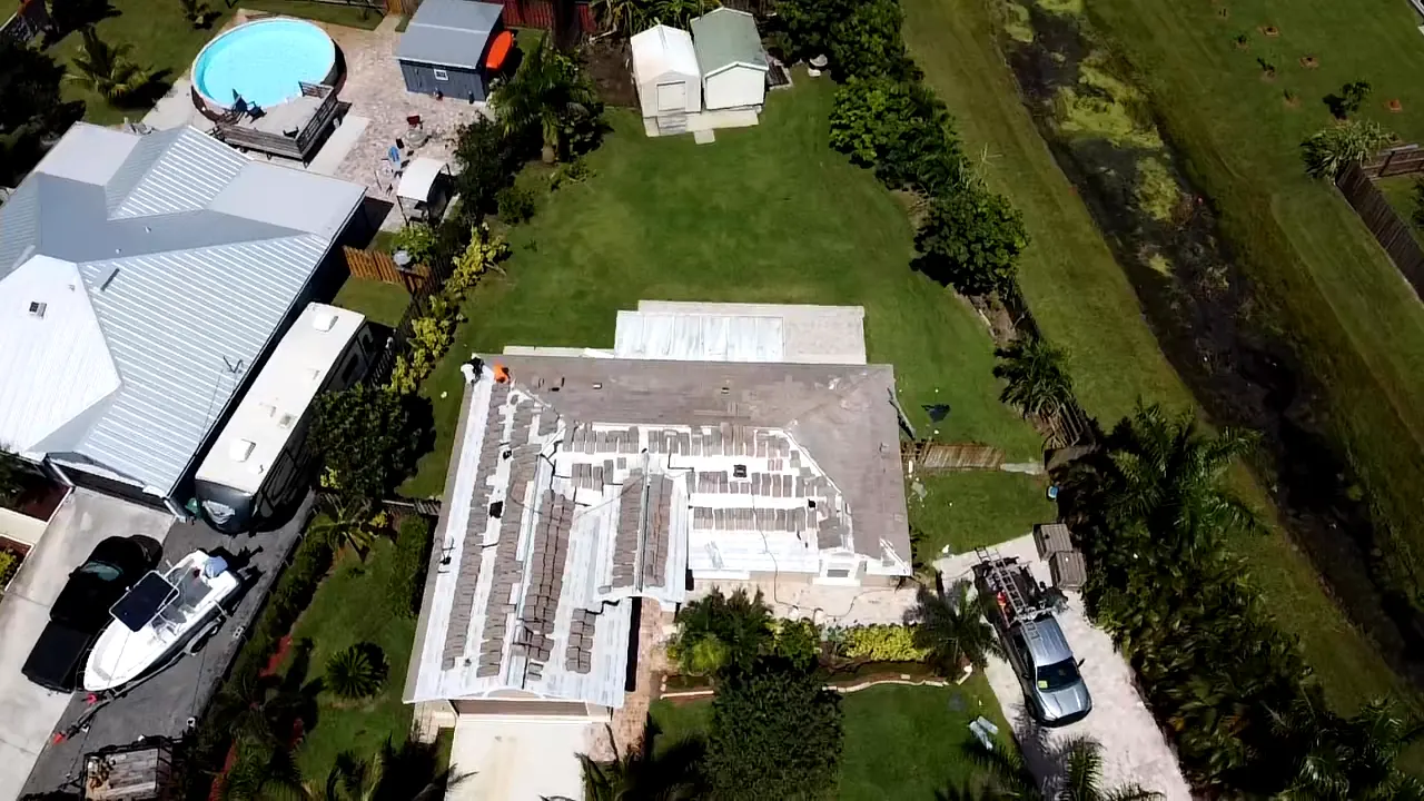 Aerial view of a low-slope residential roof during surface preparation.