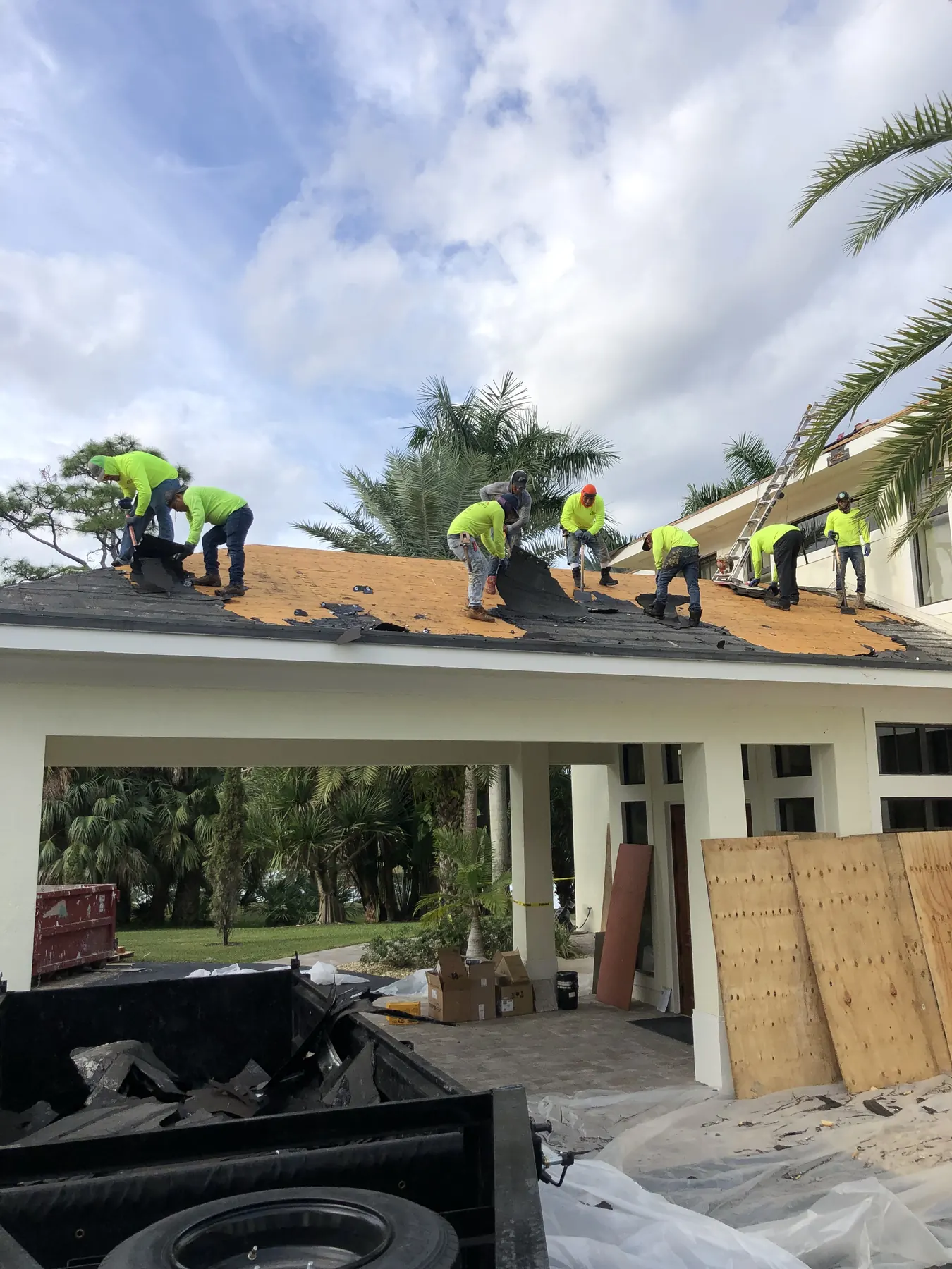 Roofing crew working across a pitched tile roof during installation.