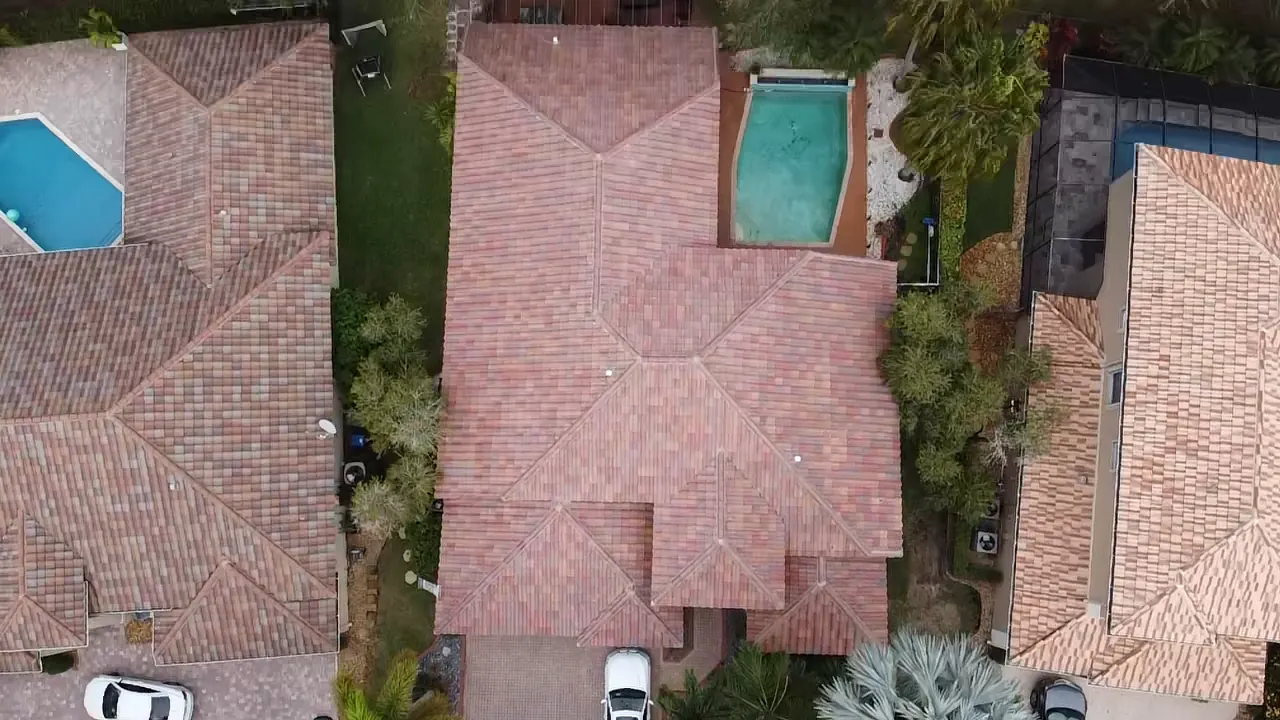 Top-down aerial view of a weathered red tile roof on a South Florida home.