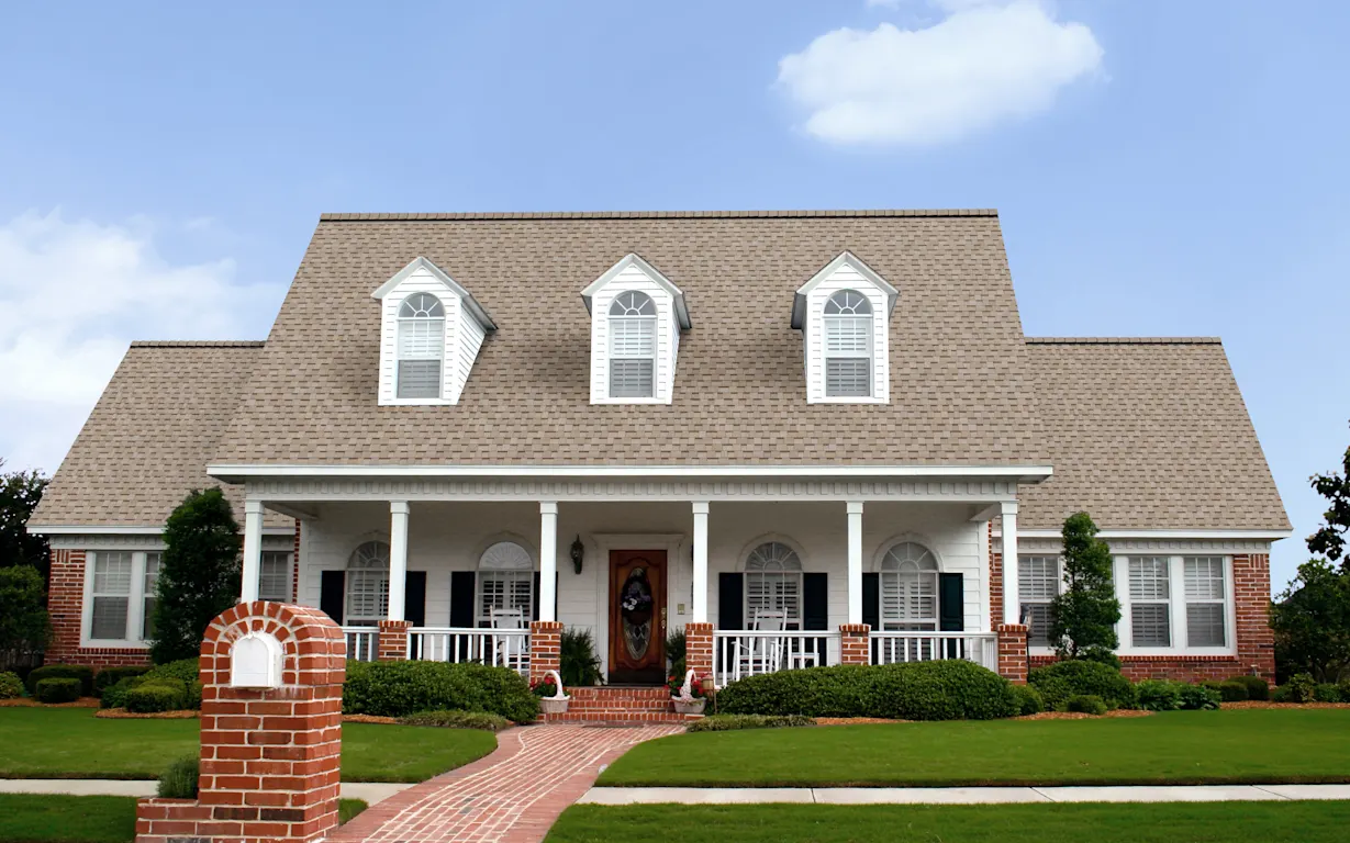 Owens Corning manufacturer reference showing TruDefinition Duration shingles in Amber on a brick-and-siding home.
