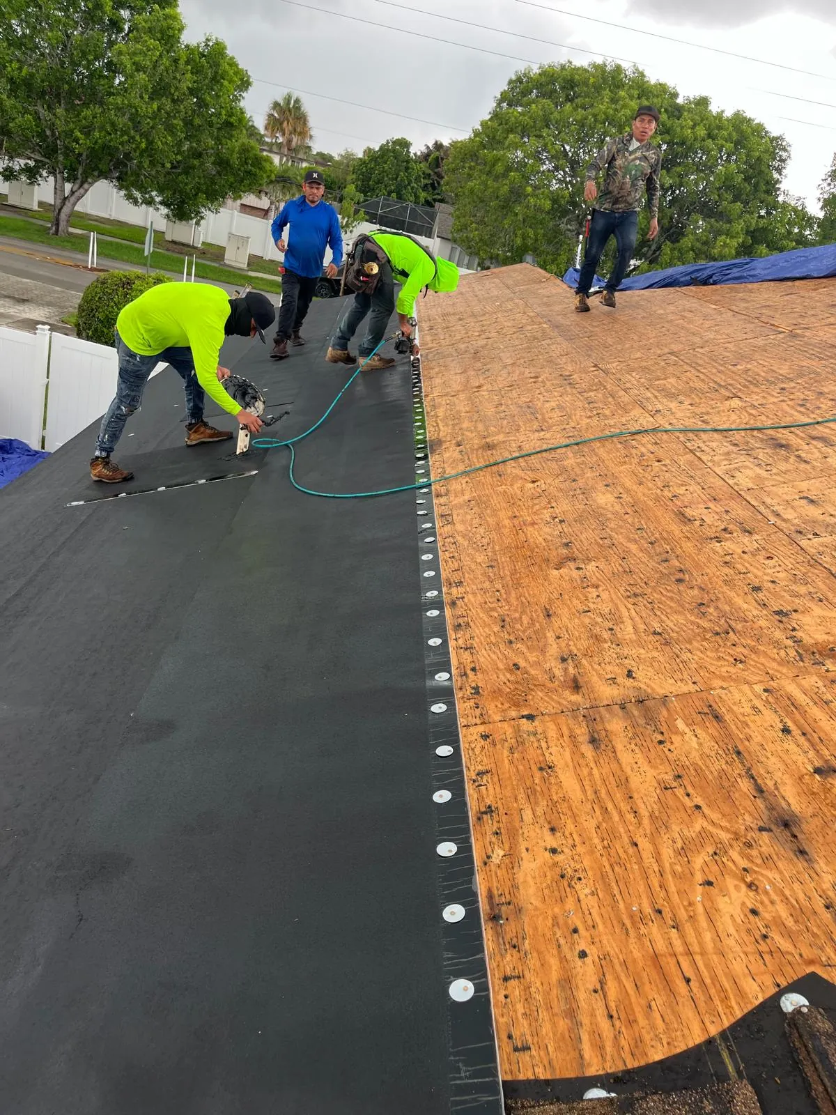 M&M Roofing crew installing Polystick IR-Xe underlayment directly over a plywood roof deck for an asphalt shingle roof.
