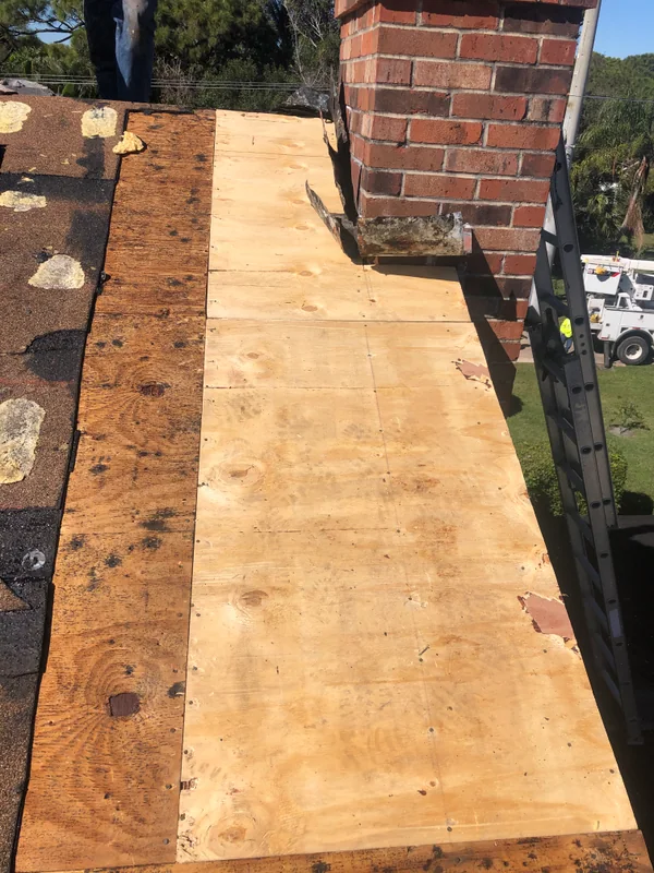 New plywood decking installed around a chimney during a tile roof repair