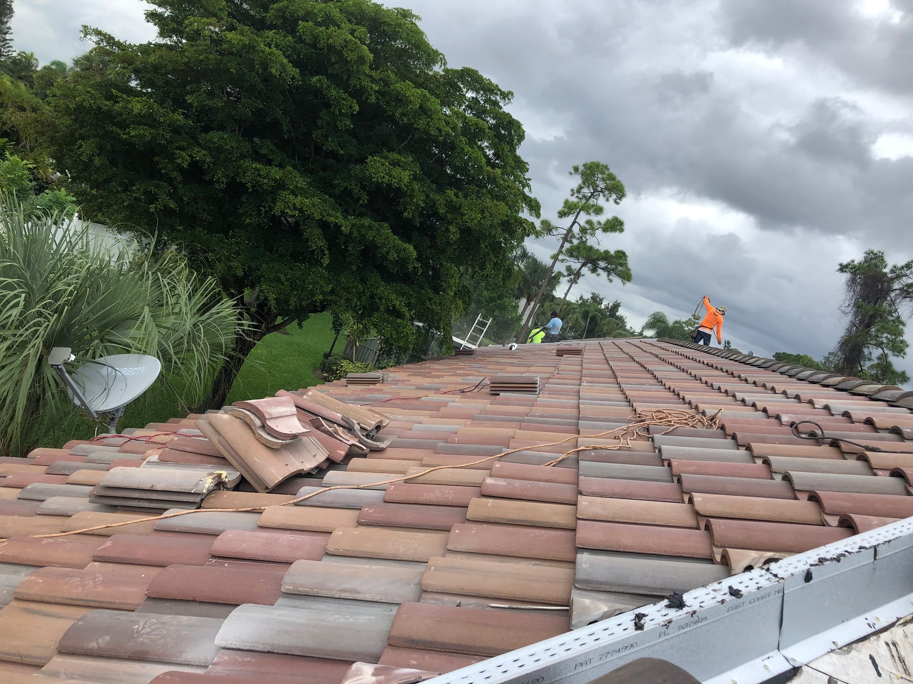 Barcelona 900 concrete roof tile installation in progress with roofers working across a South Florida roof.