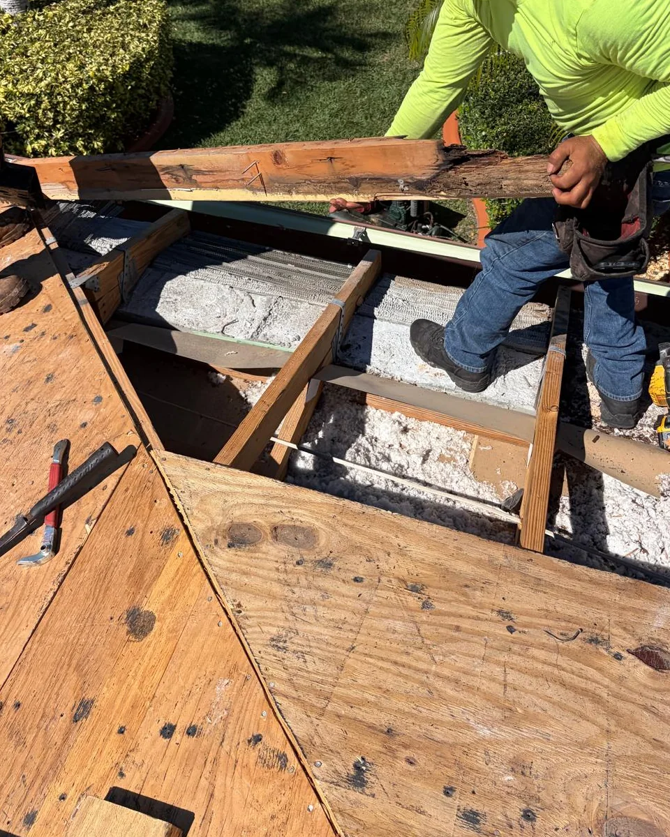 Crew member removing a rotted fascia board during a Miramar reroof