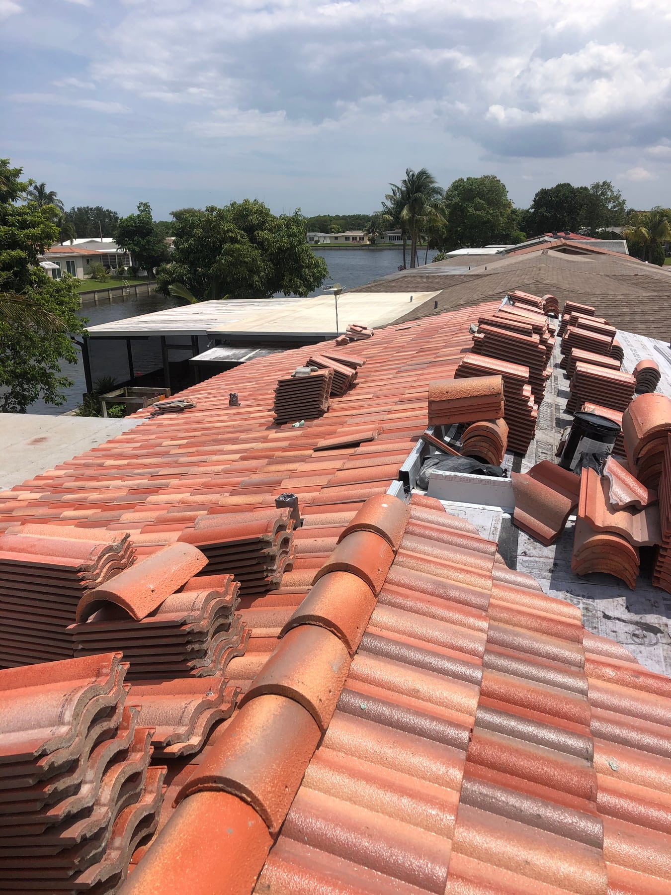 Villa 900 concrete roof tile installation with warm-colored double-roll tiles and staged hip and ridge pieces on an M&M Roofing project.