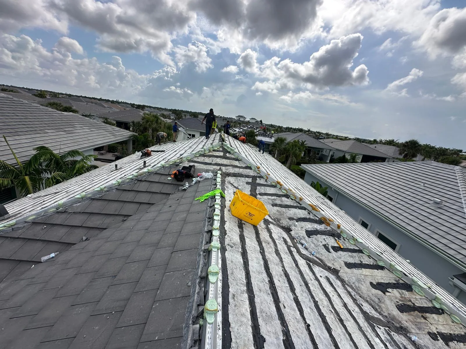 Tile roof removal in progress with old tiles still in place in the foreground